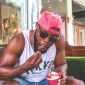 A black man in a pink baseball cap and ice cream
